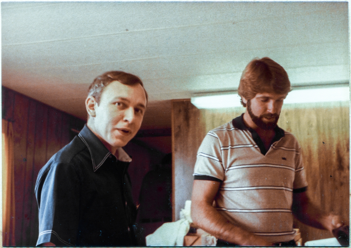 Image 011B. Inside Sheffield Steel’s field trailer at Space Shuttle Launch Complex 39-B, Kennedy Space Center, Florida, Gene Hajdaj, structural engineer for Reynolds Smith & Hills, becomes momentarily distracted and turns toward the camera, as Chris Miller, mechanical engineer for RS&H, continues to focus on the issue at hand, working with the drawings which Sheffield Steel used to fabricate and deliver the structural steel from which the Rotating Service Structure was constructed. Photo by James MacLaren.